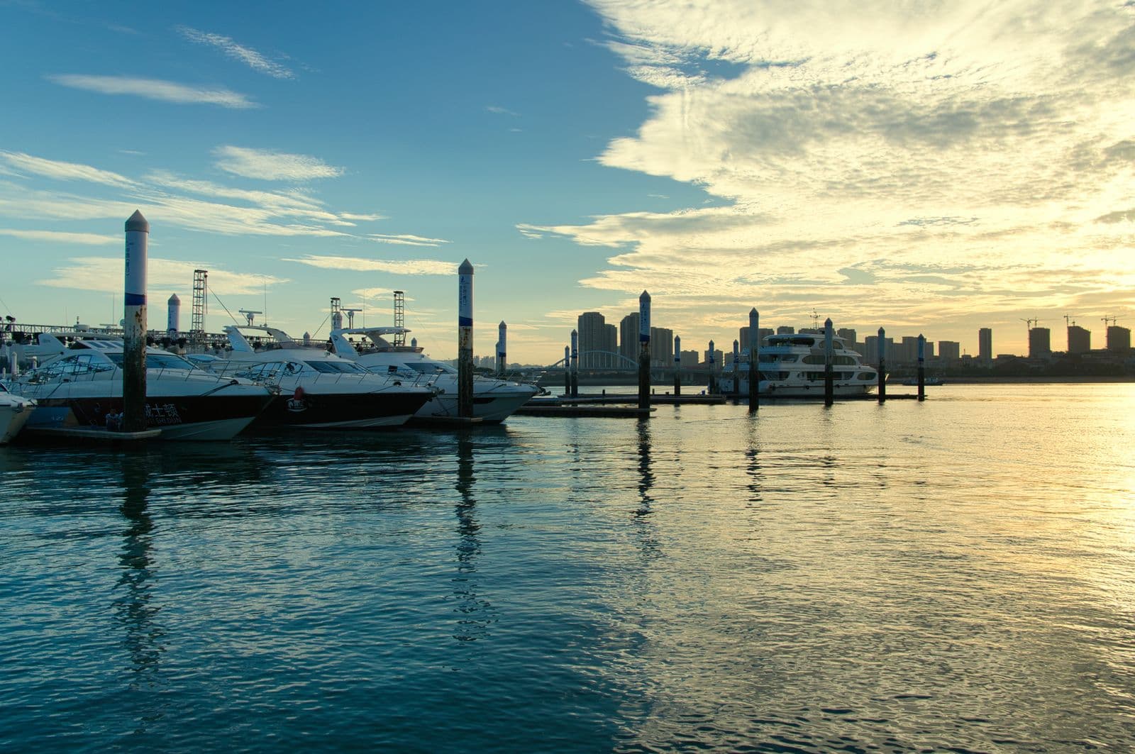Boats moored in a marina at sunset (illustrative image)